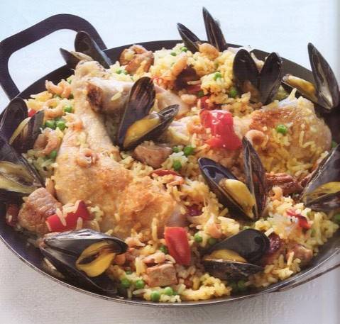 Paella met kip, zeevruchten, groenten en kruiden. recept ...