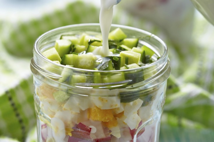 Gezonde zomerse salade met kefir in een glazen potje