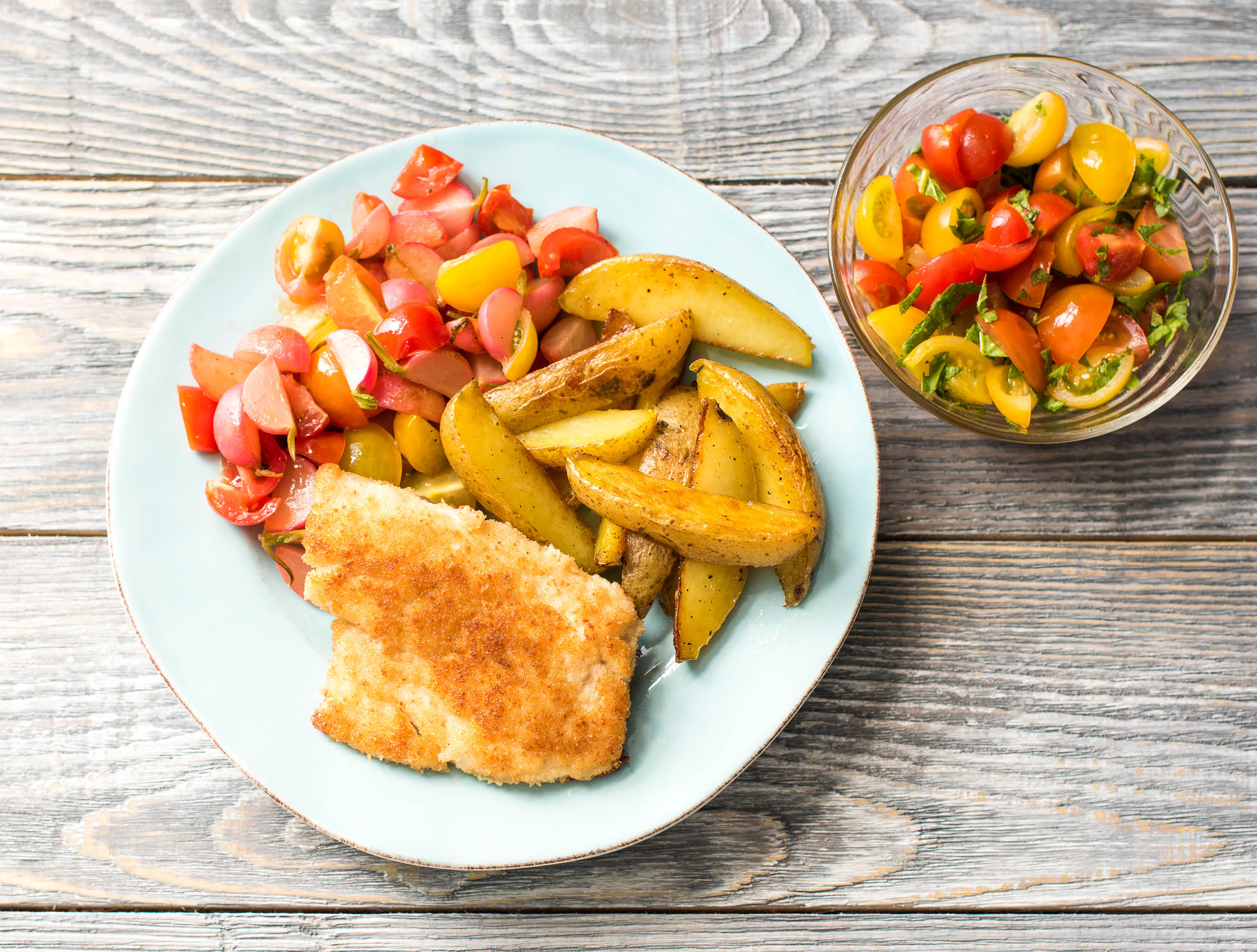 Visschnitzel met gesmoorde radijs, aardappelen en cherrytomaten ...