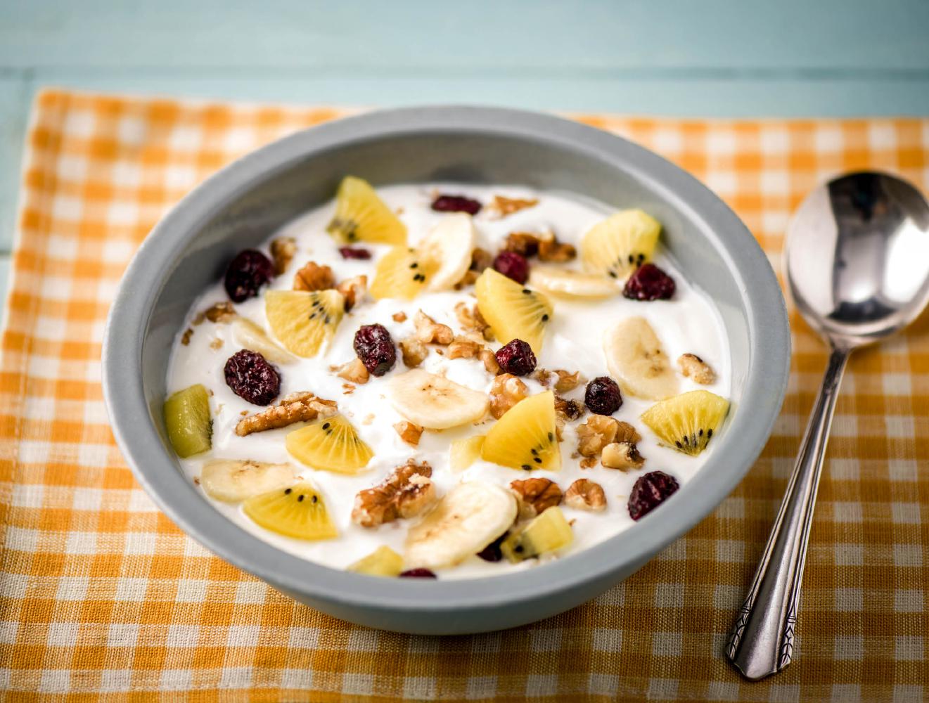 Volle yoghurt met banaan, zoete kiwi en noten-cranberrymix