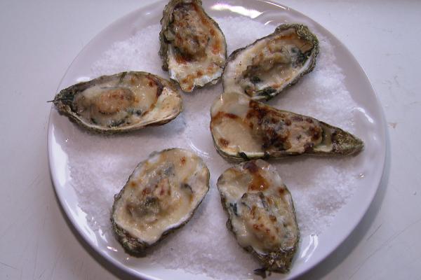 Gegratineerde oesters met champagnesaus op een bedje van ...